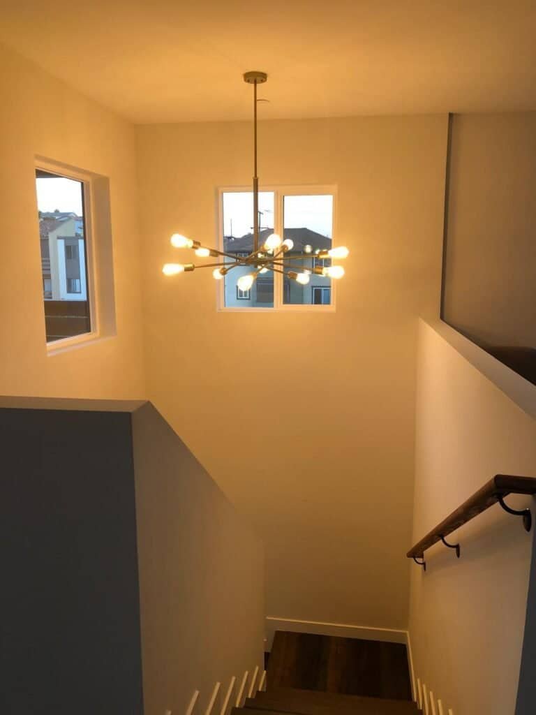 Elegant staircase with contemporary chandelier in new home interior.