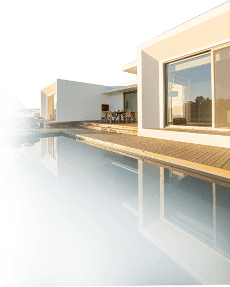 Luxury contemporary home with large glass windows and a poolside deck, showcasing innovative construction and design excellence.